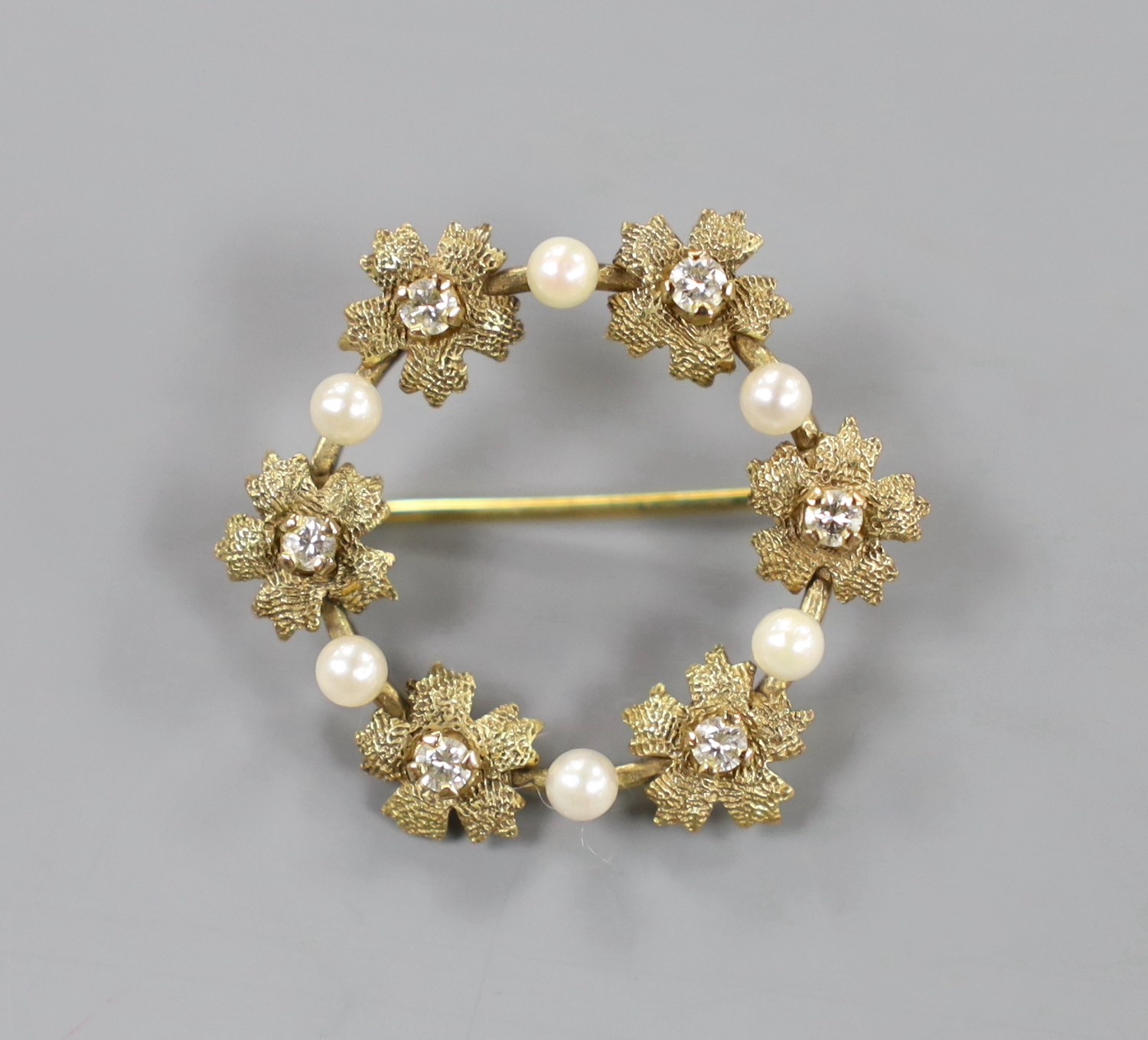 A modern 9ct gold, diamond and seed pearl set circular open work brooch, 28mm, gross weight 3.5 grams.